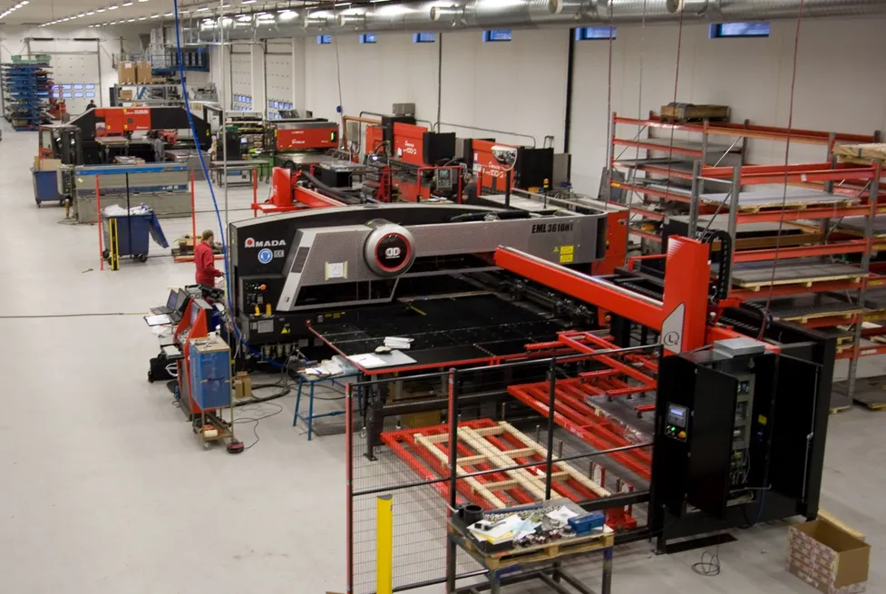 En stor rød Amada CNC-platemaskin i produksjonshallen til Vendanors metallverksted.