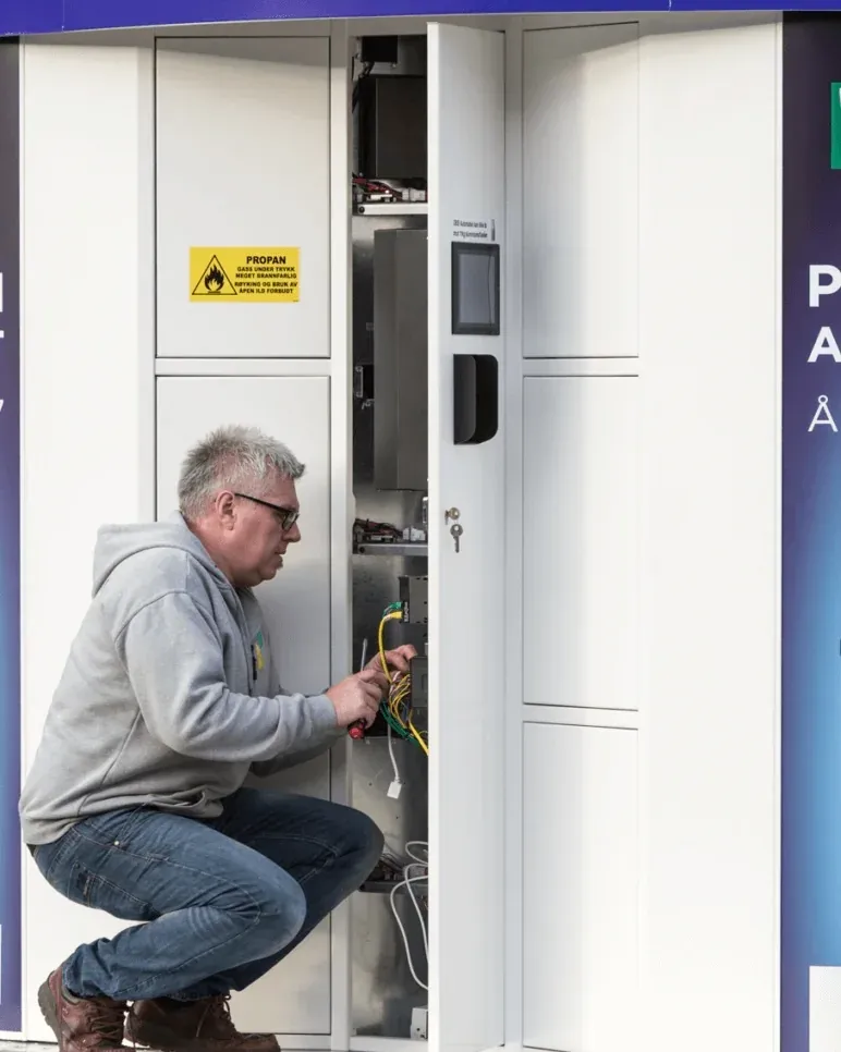 Techniker wartet die Verkabelung im Inneren eines geöffneten Vendanor Gasflaschenautomat.