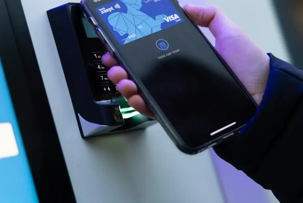 Kunde bezahlt am Zahlungsterminal eines Vendanor-Automaten, indem er ein Smartphone mit kontaktloser Visa-Karte an das Lesegerät hält.