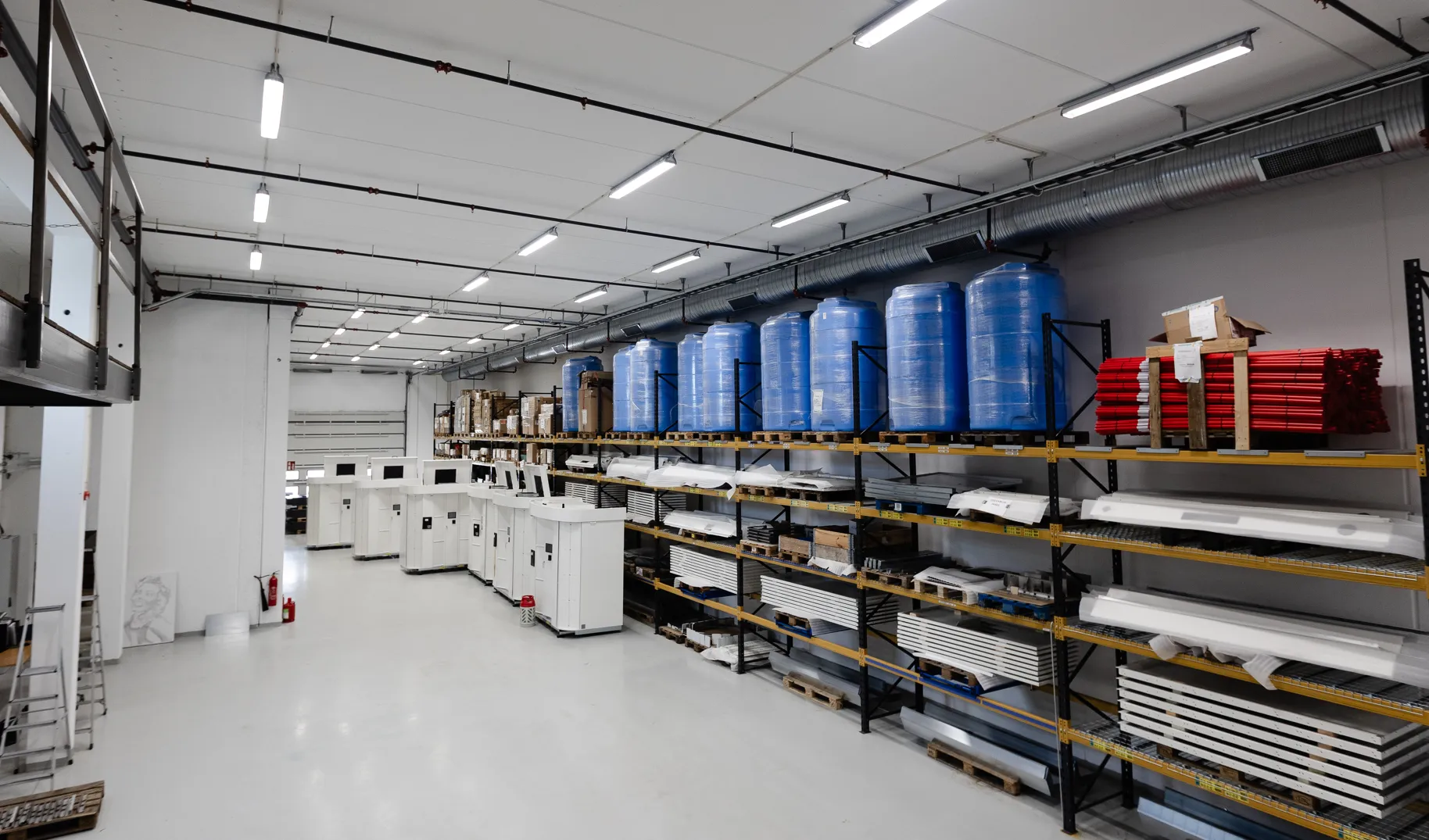 Die moderne Produktionsstätte von Vendanor mit Waschwassertanks, Komponenten und Teilen, die in Regalen an der Wand gelagert sind.