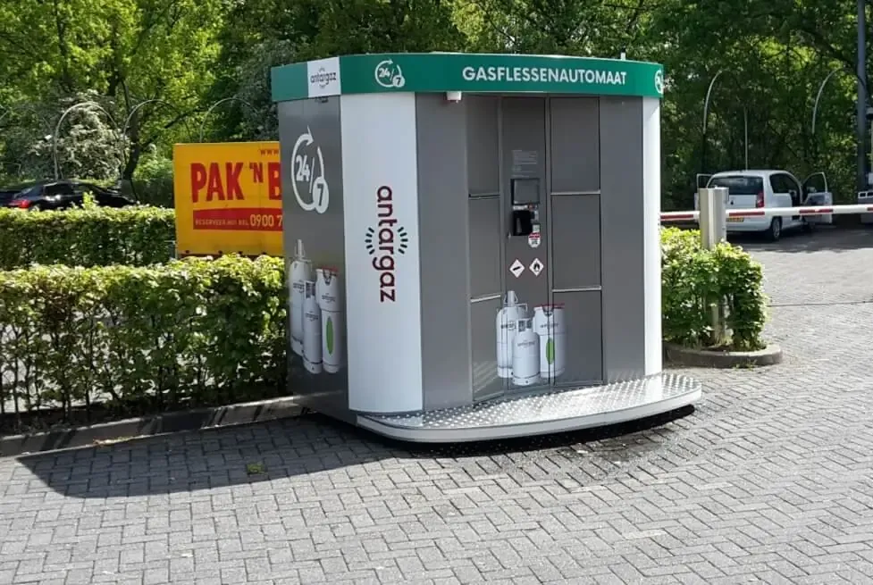 Vollständig folierter Vendanor Gasflaschenautomat im Antargaz-Design mit Aufschrift Gasflessenautomaat auf einem Parkplatz.