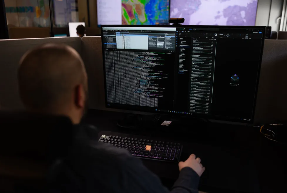 Vendanor support engineer monitoring machine software and data on dual screens in a control room.
